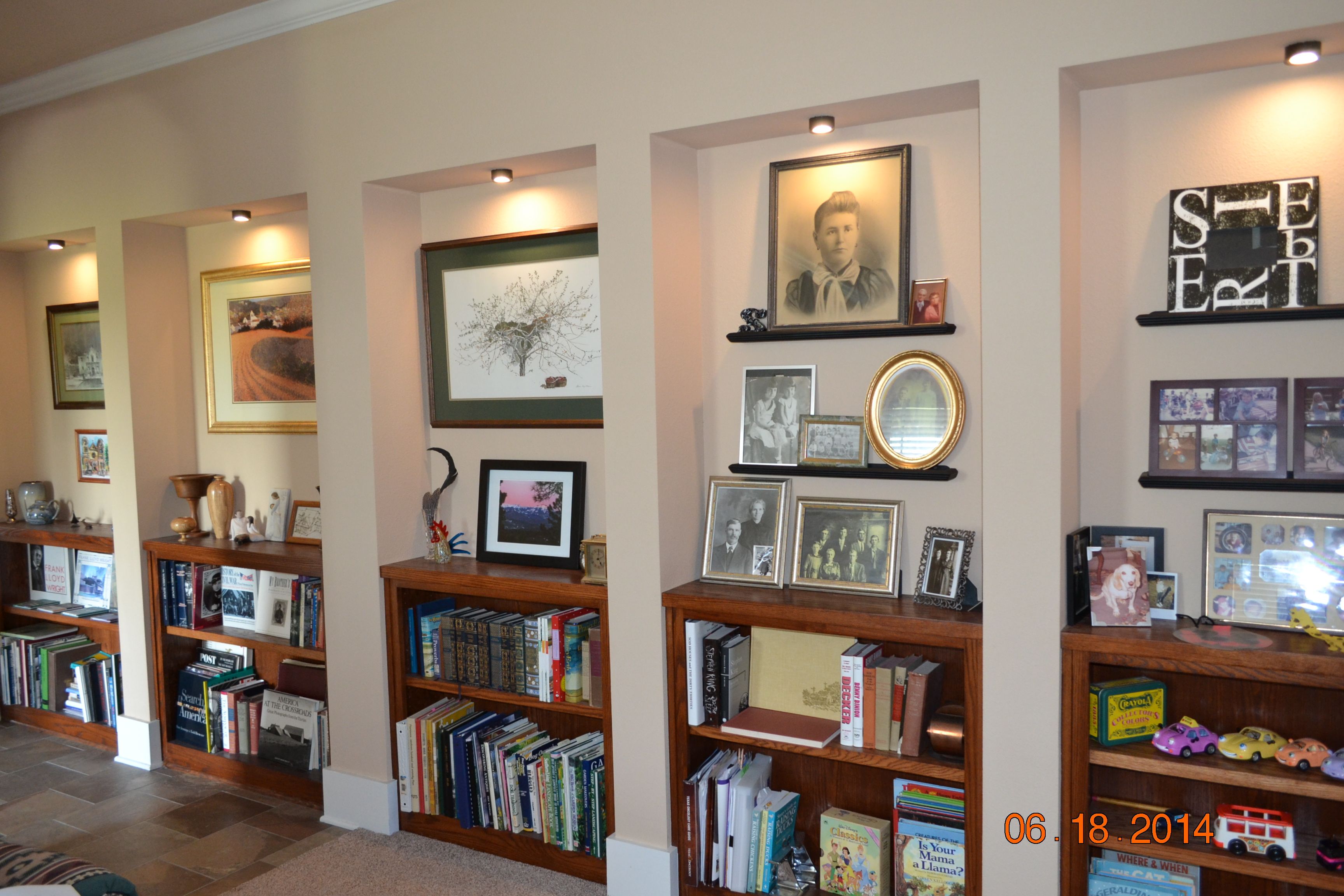 Hallway bookshelves and photo alcoves recessed and lighted for interest